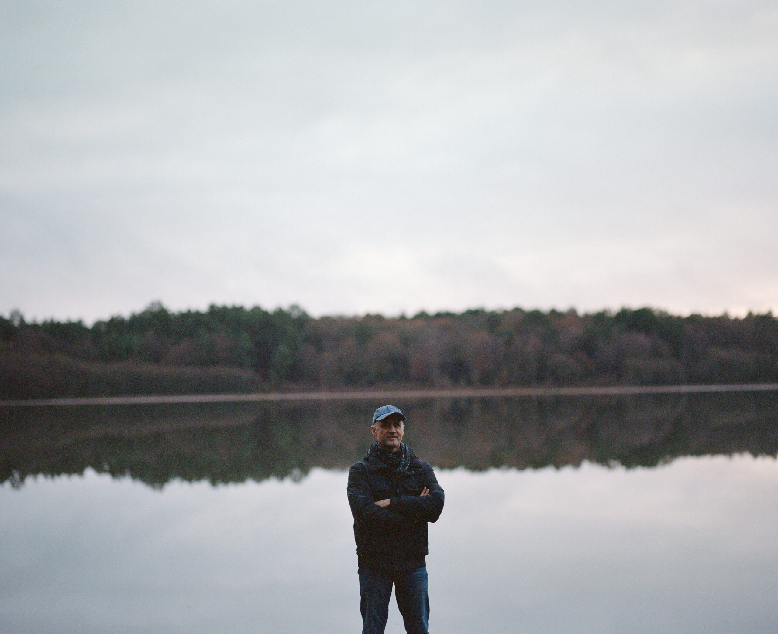 Luc Marescot stands in front of a lake in the middle of the Brocéliande Forest in France.