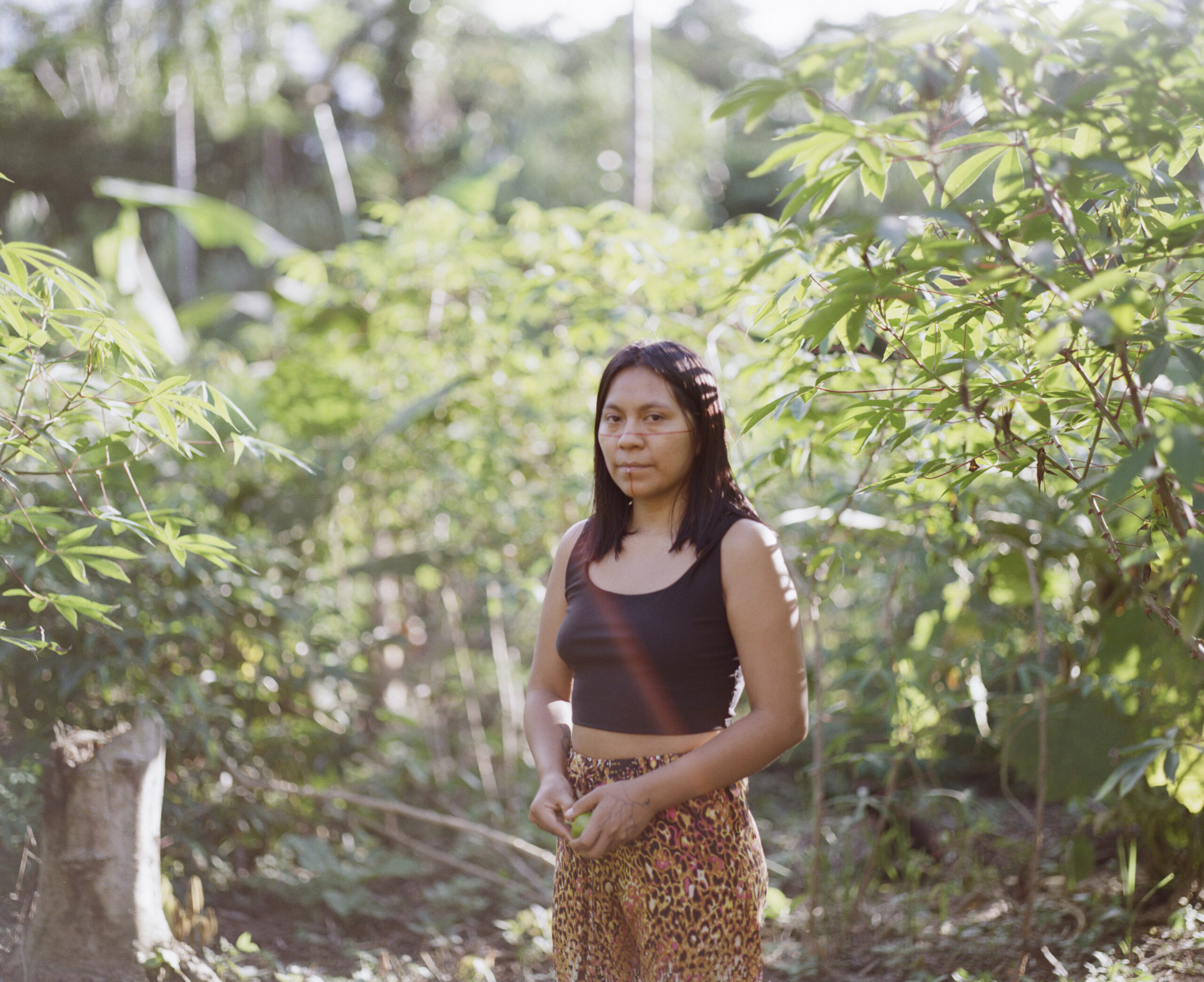 Sani Montahuano Ushigua stands amongst the green plants at Itia Mamá Minga.