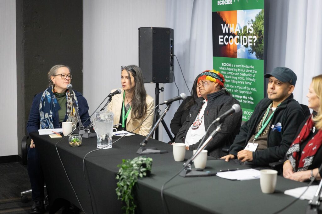 Jojo Mehta sits on a panel of six people, speaking about ecocide, at the COP15 Biodiversity Summit in Montreal in 2022.